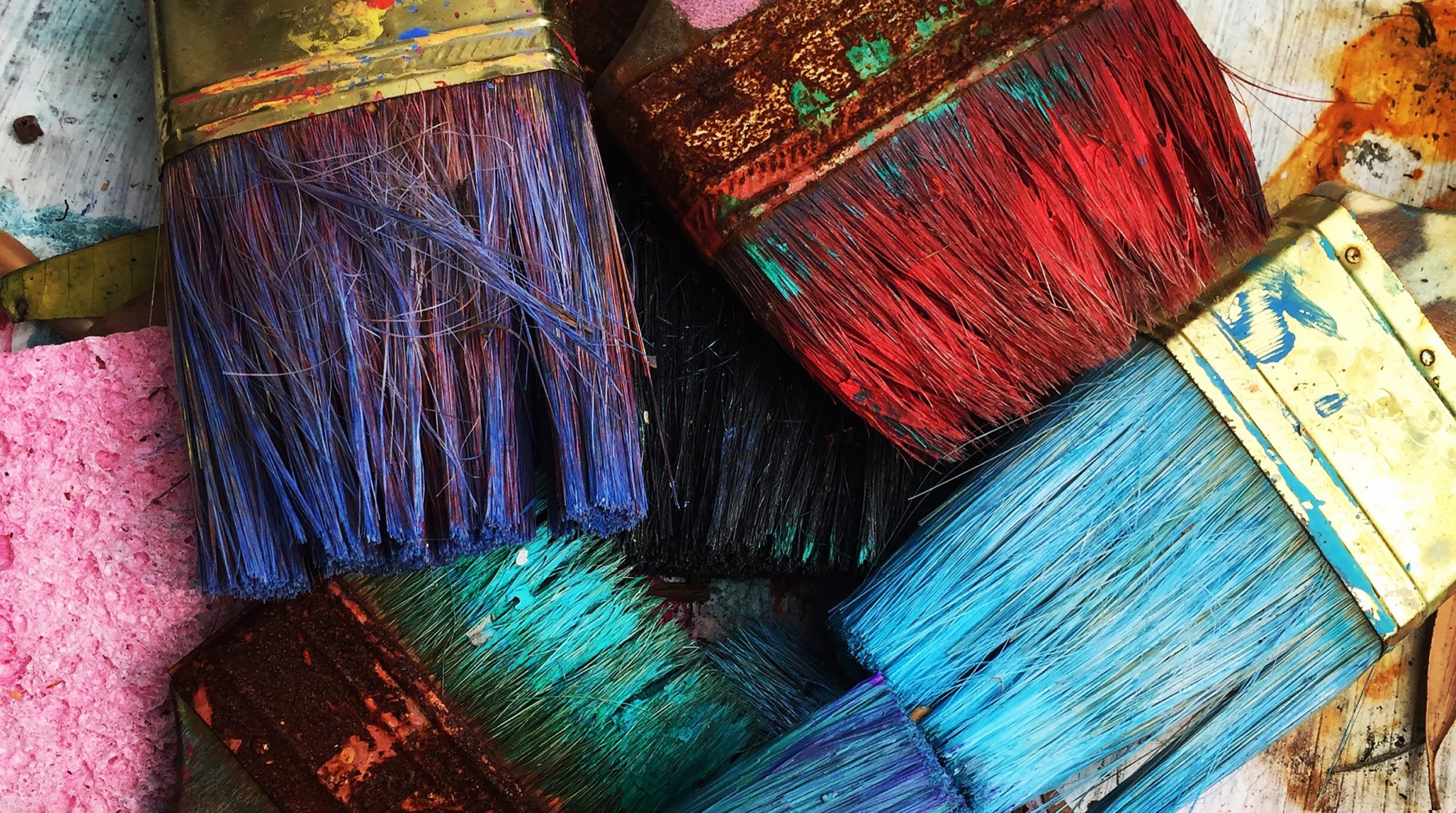 Our Services page banner image. Closeup of six paint-stained brushes