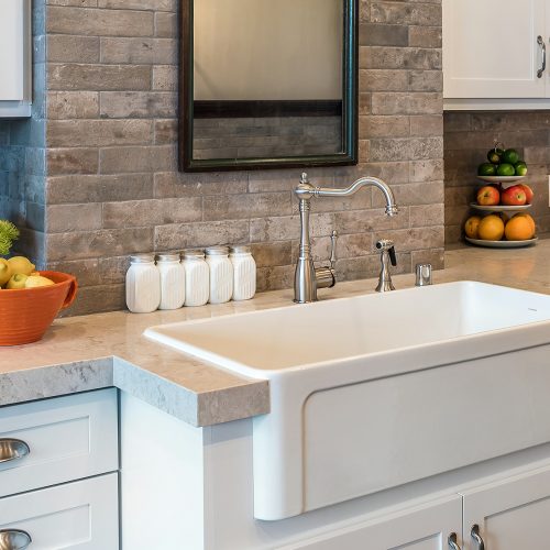 Kitchen white farmhouse sink with stone backsplash, marble countertop