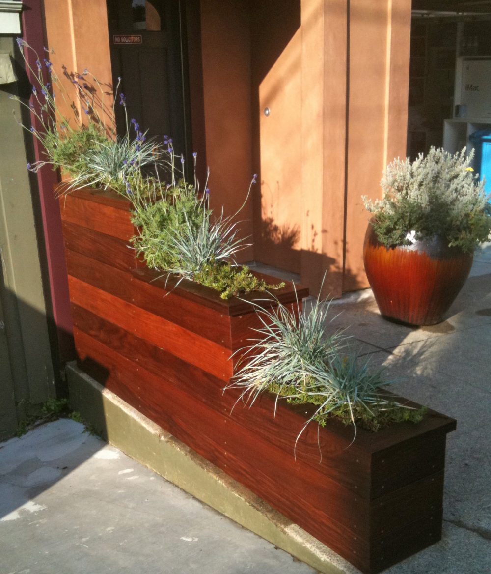 Three level rectangular redwood planter box next to front door