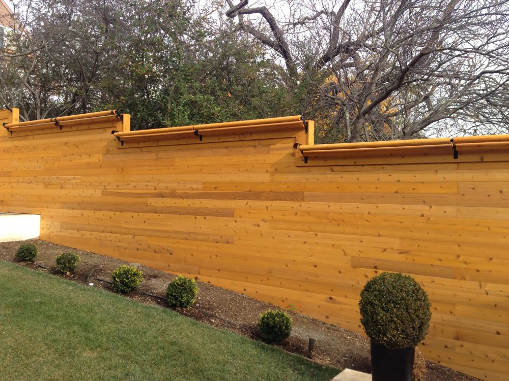 Beautiful pine colored wood slat fencing cut to match property elevation