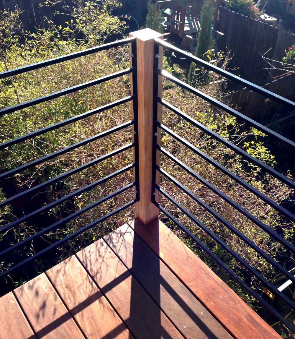 Close up of second story wood deck corner with cable railing and cable as top rail